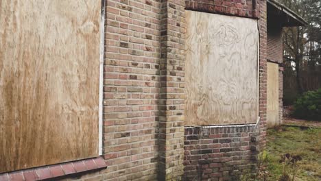 abandoned brick house with boarded windows