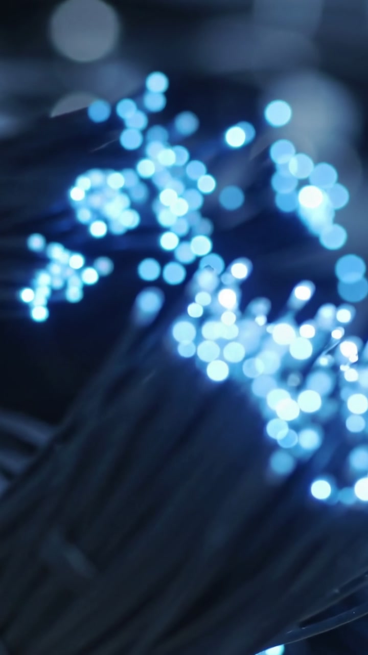 Camera pulling focus, fiber-optic bundle shifting from sharp tips to blue bokeh for tech design