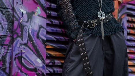 close up outdoor fashion shot showing clothes jewellery and accessories of alternative style woman against graffiti covered wall in london city street uk in real time 1