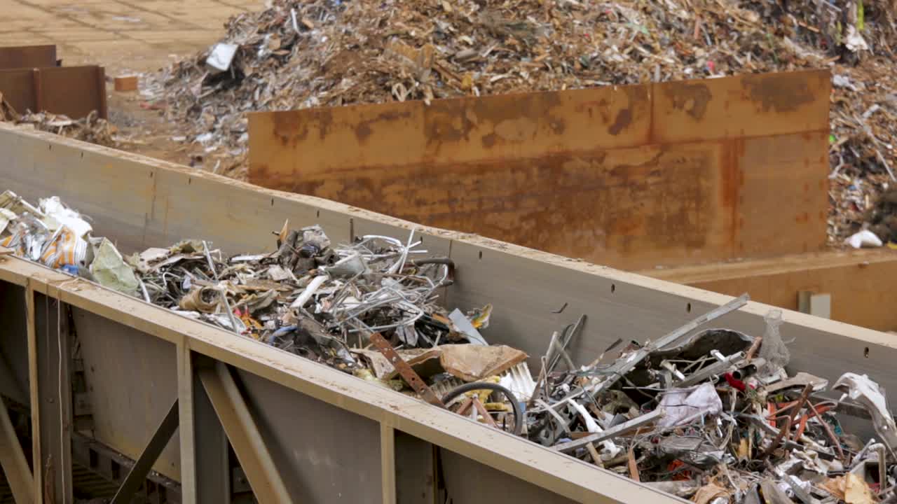 An industrial scrapyard with large piles of mixed waste materials, aerial view