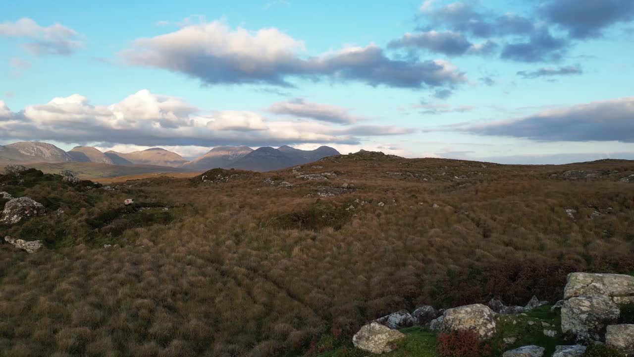 앞면 에 바위 와 침착 한 호수 가 있는 코네마라 호수 의 드론  ⁇  과 멀리 에 있는 비나 베올라 산맥 의 공중  ⁇
