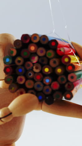 figurine carrying bunch of colored pencil