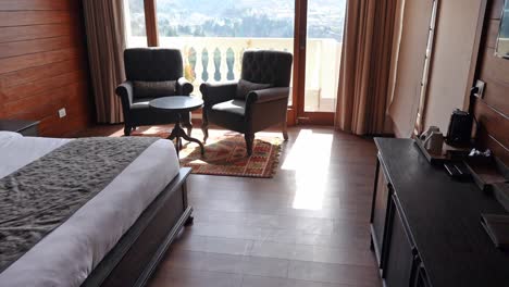 interior details of an empty hotel room with comfortable bed and armchairs for guests - panning shot