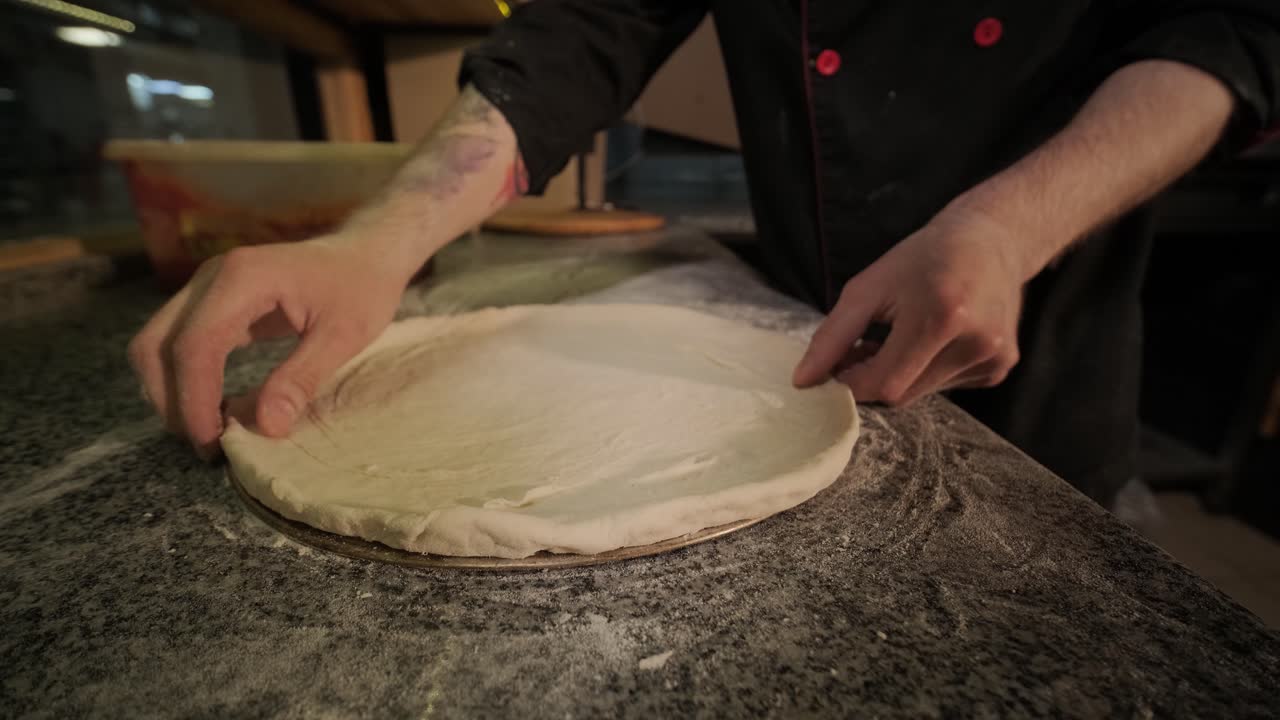 Lo chef prepara la pasta per la pizza