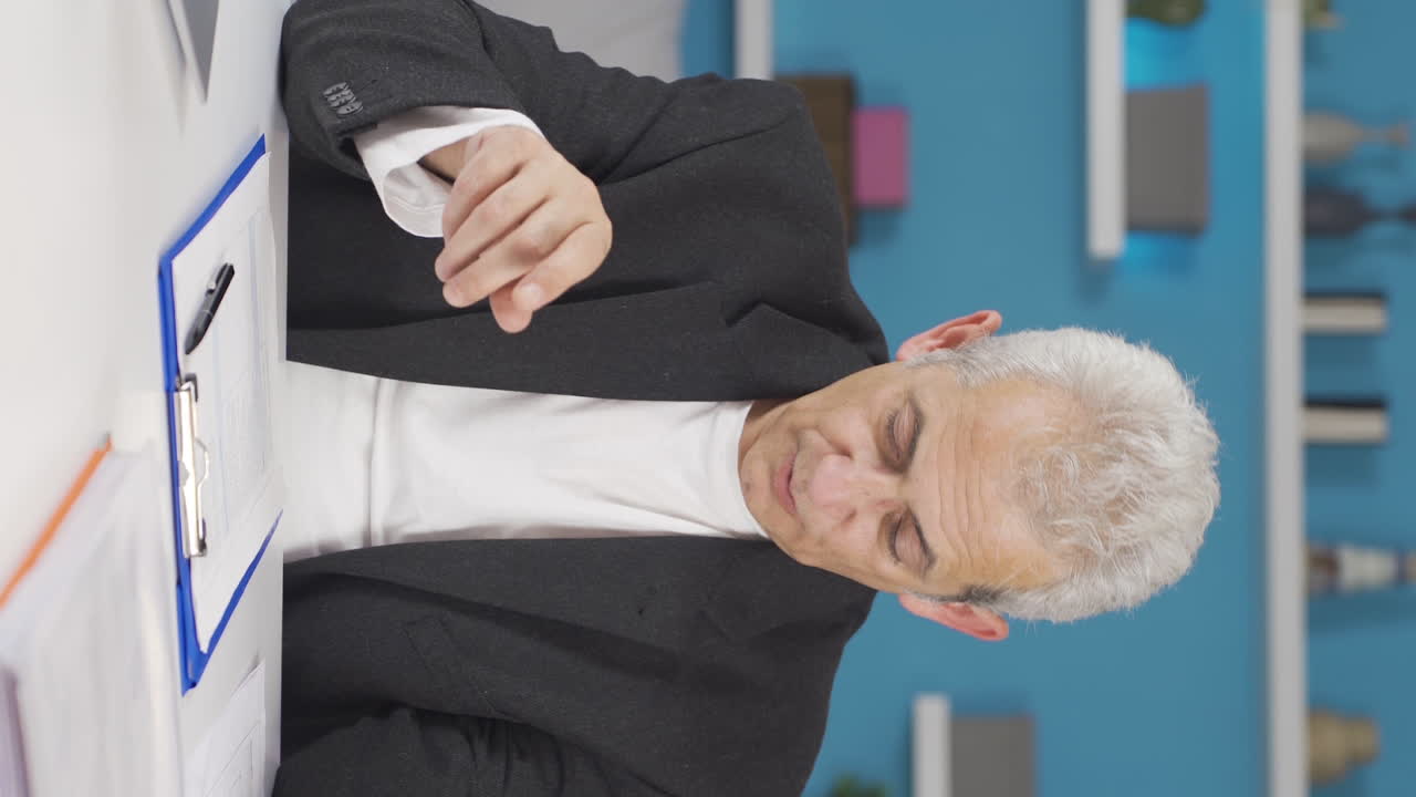 홈 오피스 근로자의 수직 비디오가 그의 일에서 휴식을 취하고 있습니다.