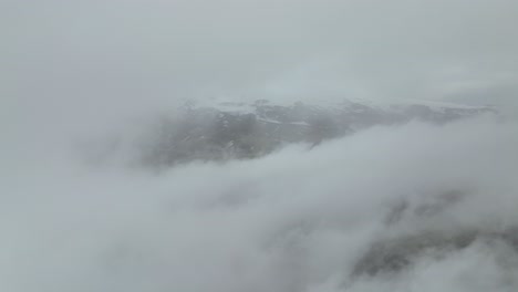 an aerial shot of dense fog enveloping the mountains in hafursey, iceland, creating a serene and mystical atmosphere.