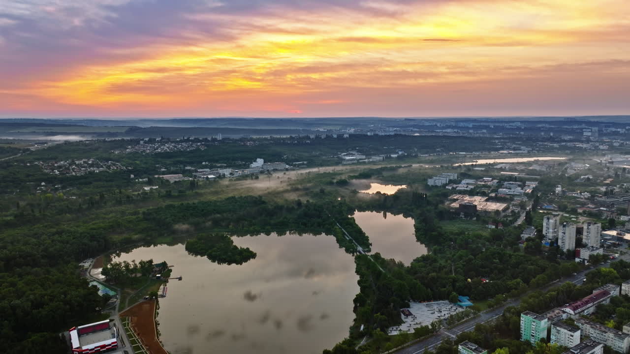 Aerial drone view of a lake surrounded by trees in Chisinau, Moldova at sunrise