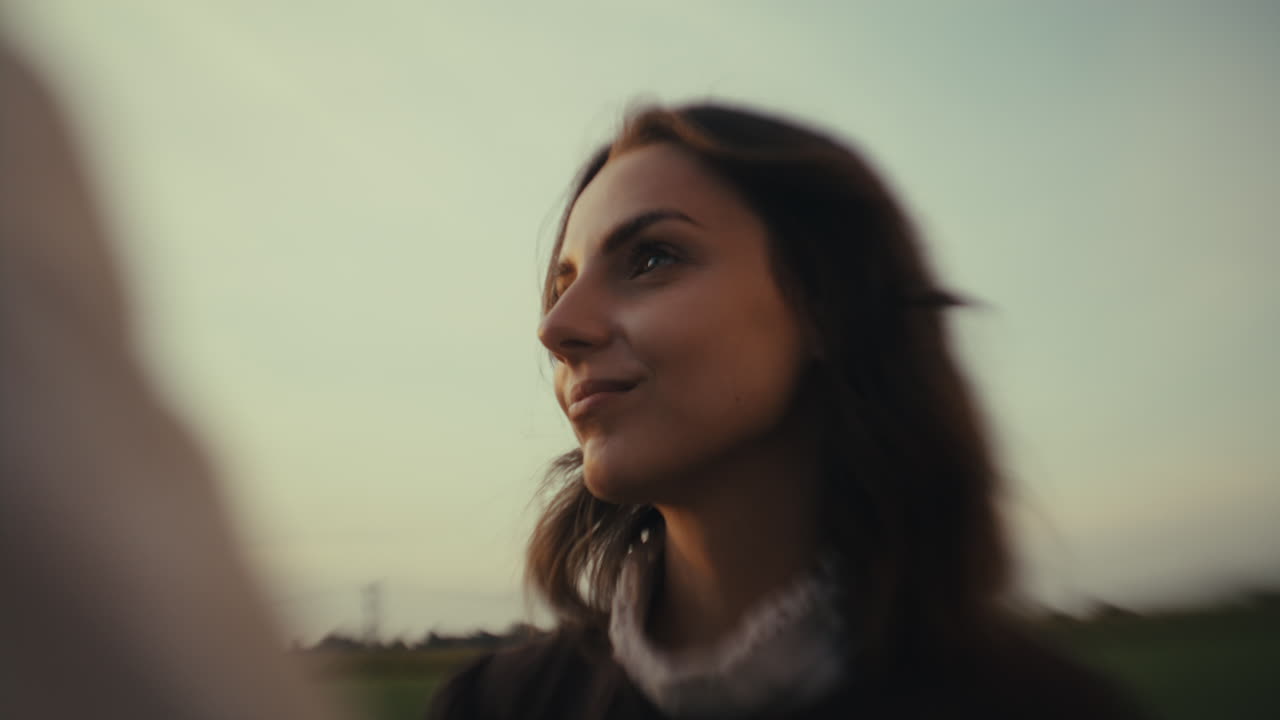 Portrait of a young woman looking towards the sky at dusk