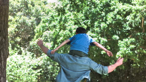 man in slow motion holding his son on his shoulders