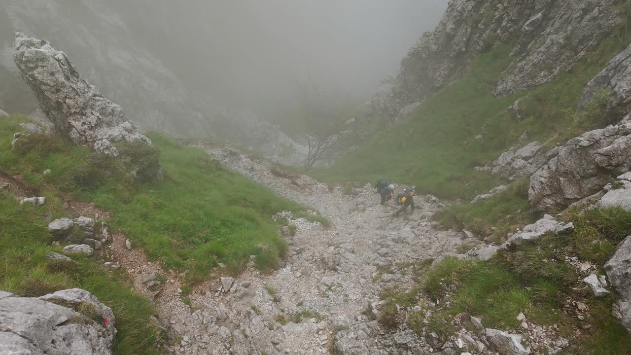 Lombardy, Italy - Mountain Climbers Navigating the Fog-covered, Rocky Terrain of Grignetta - High Angle Shot