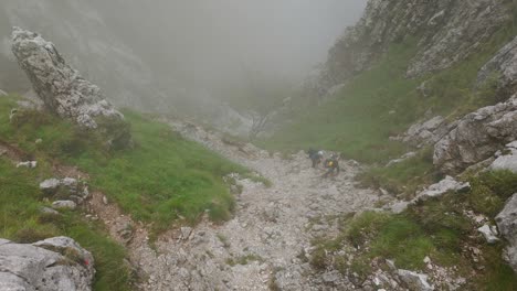 lombardy, italy - mountain climbers navigating the fog-covered, rocky terrain of grignetta - high angle shot