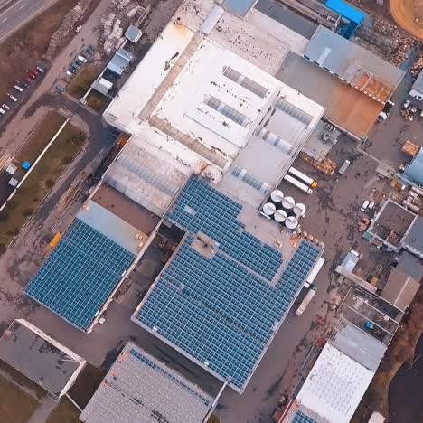 plant or fa?tory with solar panels on the roof. electricity from sun energy. additional green power. video from the top