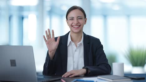 happy indian business woman waving hi to the camera
