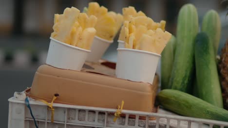 a fruit basket close-up shot with pineapple, cucumber, and other fruits