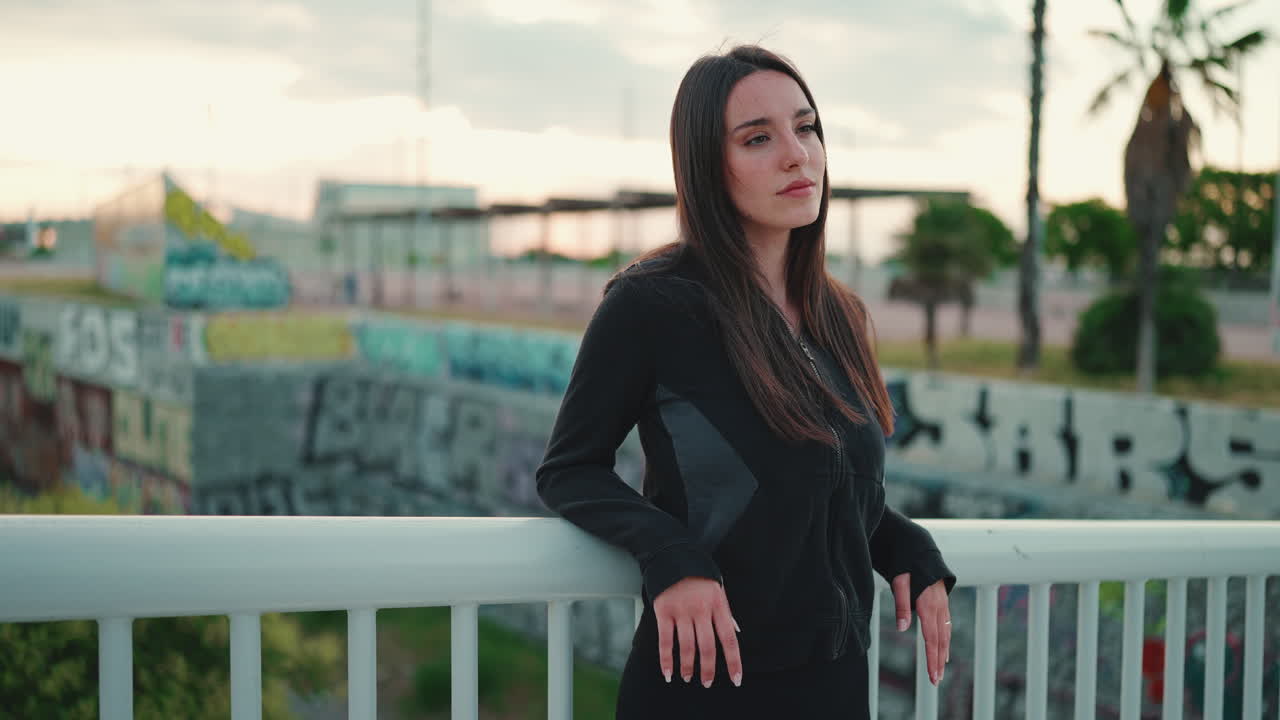 Una donna si trova su un ponte e guarda la città