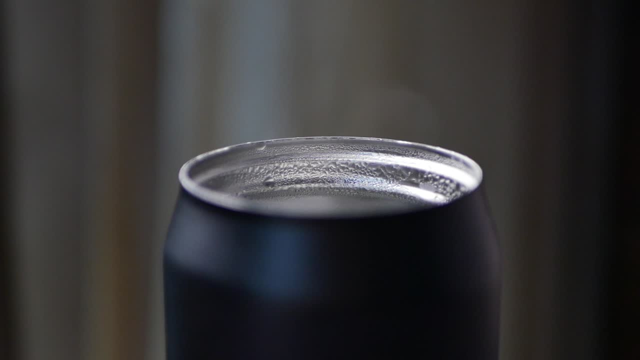Close-up of a black can lid with condensation