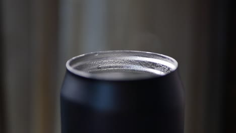 primer plano de una tapa de lata negra con condensación