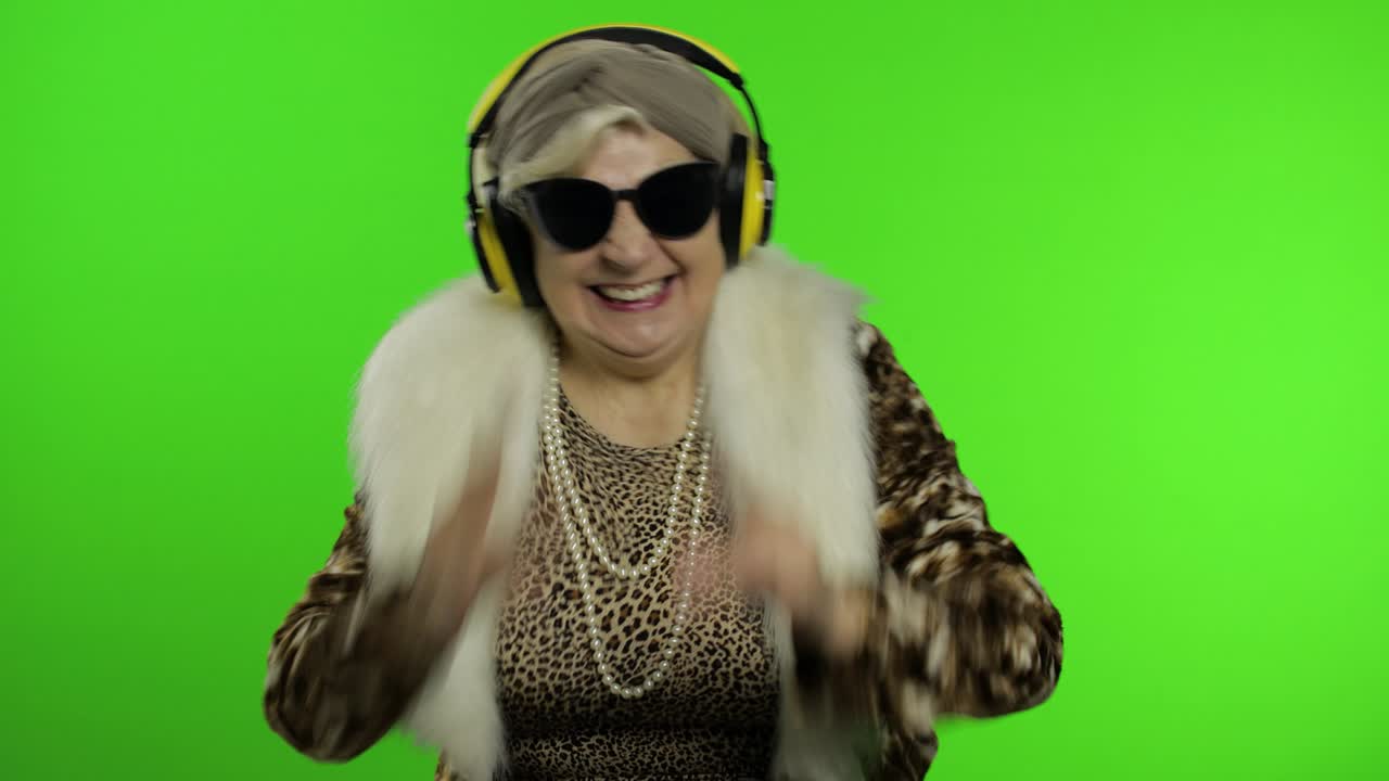 Nonna anziana. Donna caucasica. Balla, festeggia, ascolta musica. Chroma key.