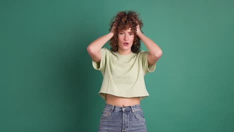 Woman surprised on green background