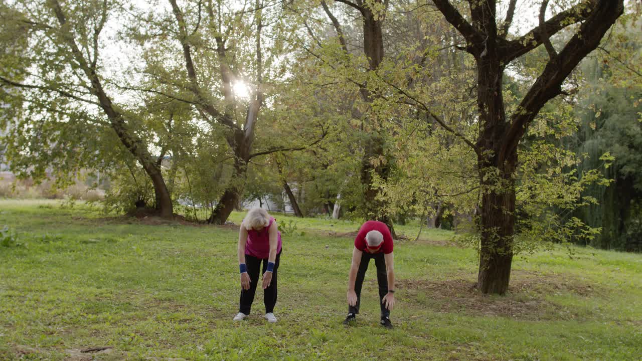 pareja activa haciendo ejercicios físicos deportivos al aire libre en el parque de la ciudad. entrenamiento de estiramiento por la mañana