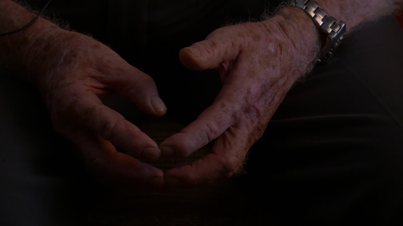 Close-up of the hands of an elderly person (grandfather) at rest, with skin marked by the passage of time