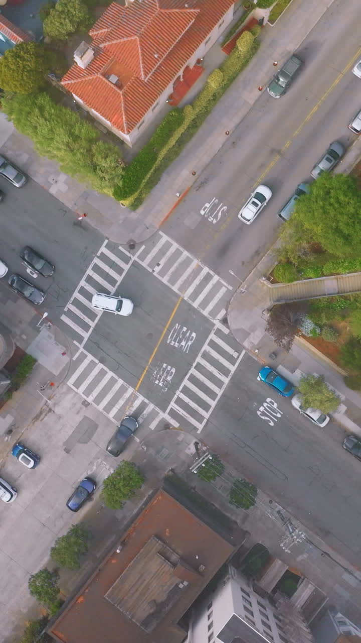 Usual crossroads in one of the streets of San Francisco. Some cars going by the roads of the city. Top view. Vertical video