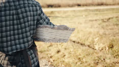 agricultora caminando en cámara lenta sosteniendo una cesta de mimbre