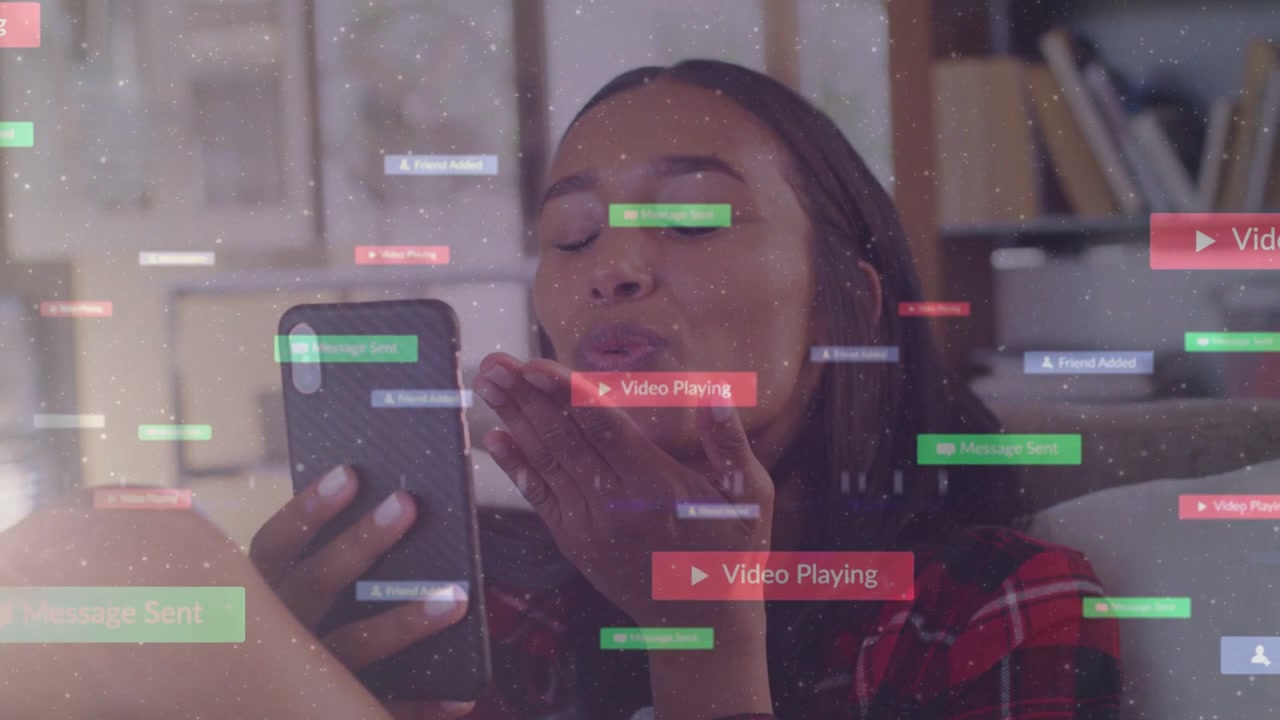 Video verticale: Toccando la UI Play, donna in plaid rosso che guarda un video sul divano inviando baci al telefono