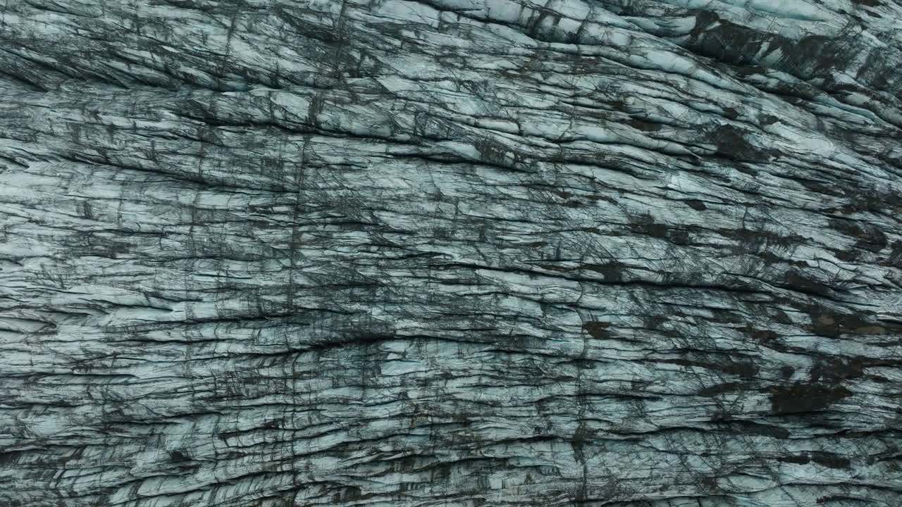 Top down aerial drone footage of Svínafellsjökull Glacier in Iceland, highlighting abstract ice patterns. Part 1.