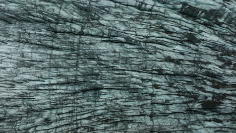 top down aerial drone footage of svínafellsjökull glacier in iceland, highlighting abstract ice patterns. part 1.