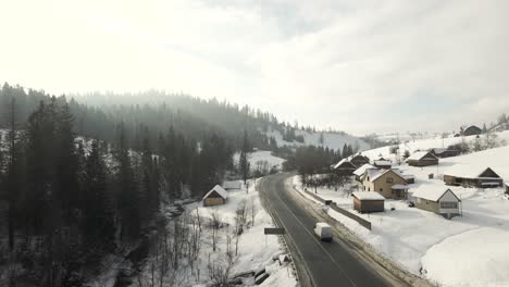 Cars-Traveling-on-Snowy-Road-in-Ukraine-Mountains---Aerial