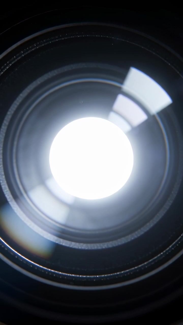 Pystysuuntainen video: Softbox liikkuu, linssikokoonpano heijastaa keskuslevyä ja softboxin korostusta, studiossa
