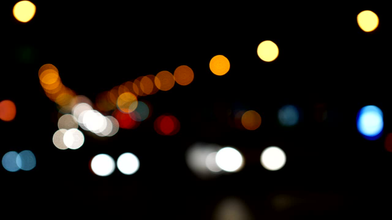 luces desenfocadas calle de los ángeles resumen. fondo borroso de la ciudad. círculos de bokeh en movimiento del tráfico nocturno.