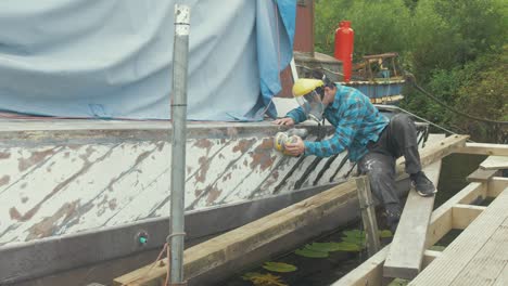 Sanding-the-Mahogany-Planked-Hull-of-a-wooden-boat