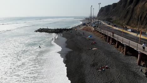 4k daytime aerial video of the pacific ocean hitting the cobblestone beach of miraflores in lima, peru