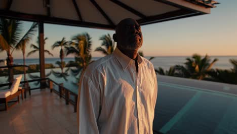 man enjoying the sunset view from a luxury resort balcony