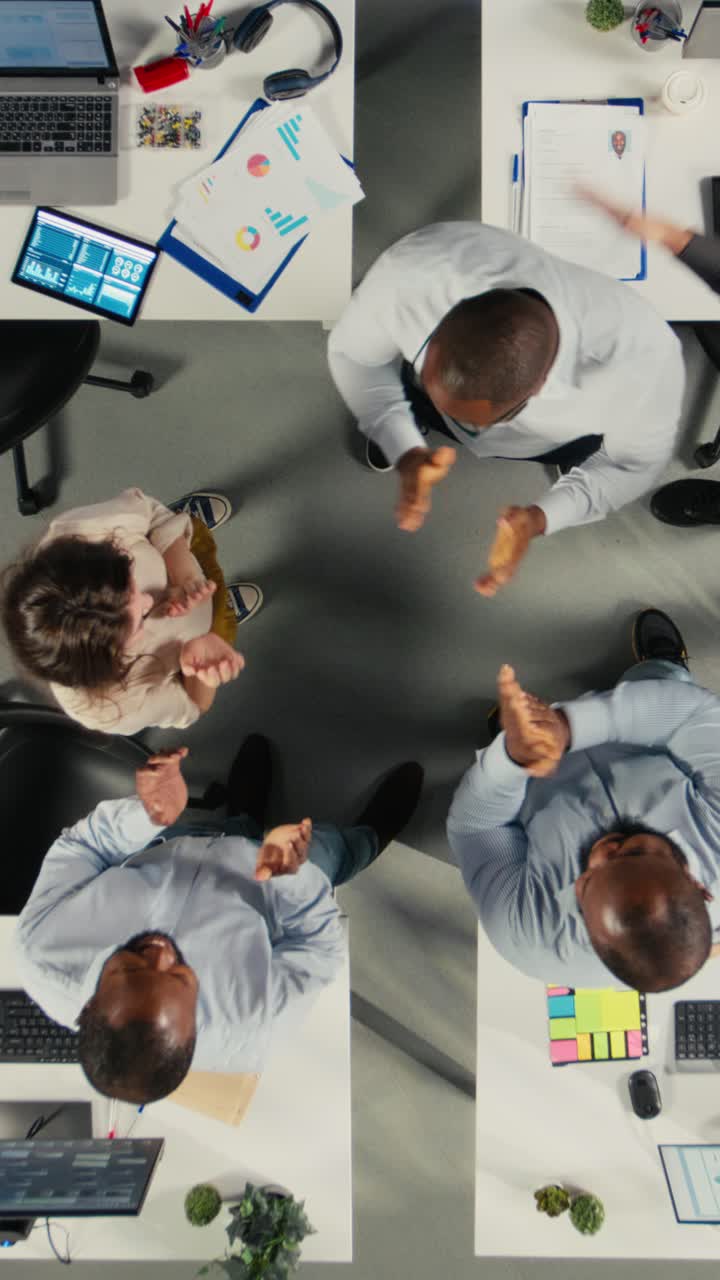 Vertical Video Top down view zoom in of professional staff uniting hands after successful tasks