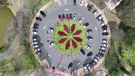 aerial view of circular parking lot with flower bed in the center