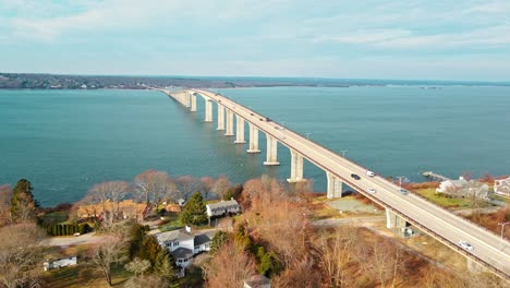 A-sideways-4k-aerial-shot-of-a-long-bridge-going-through-with-water-underneath