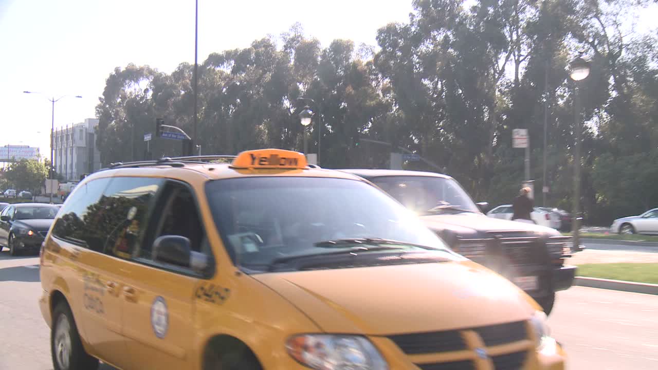 un automóvil viaja a lo largo de una calle en la ciudad del siglo de los ángeles, visto a través de la ventana trasera en un ángulo 7