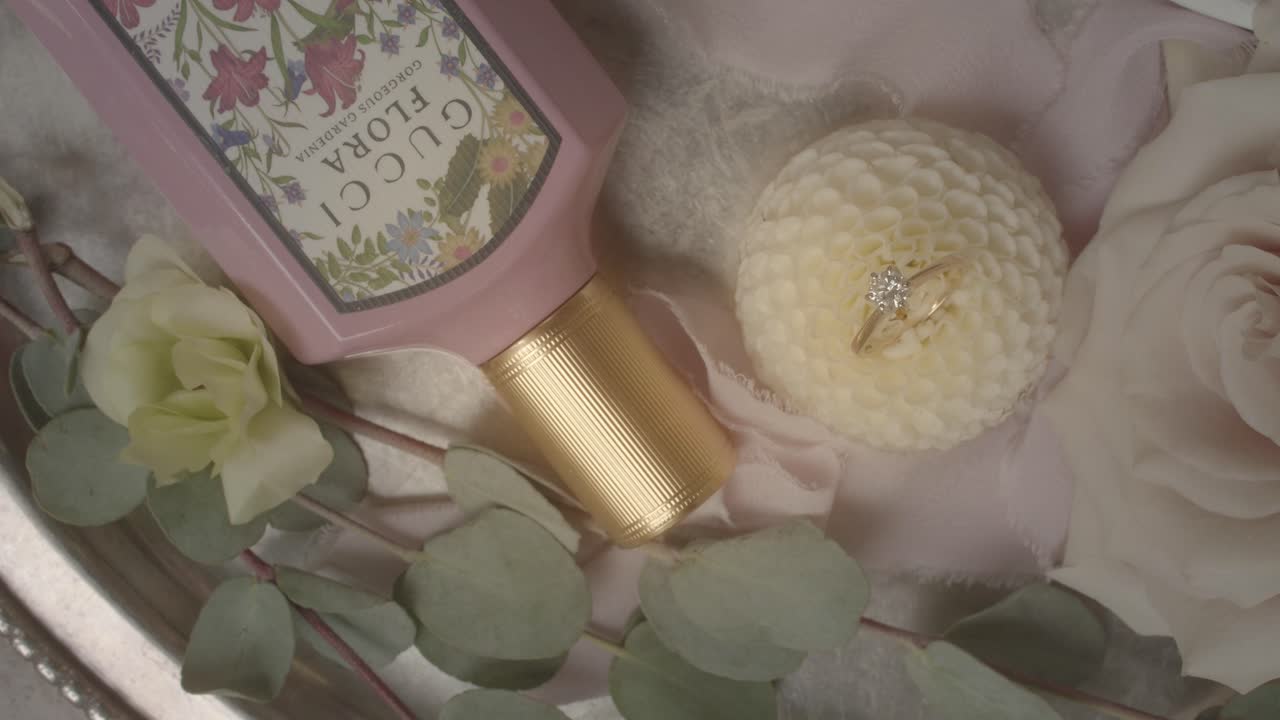 Wedding table decor with diamond ring, white roses and luxury beauty care product. Marriage concept.