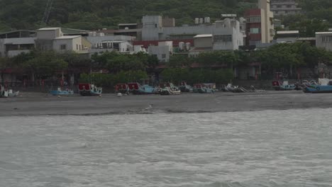 old traditional fishing boats beached on sandy shore of bali district taiwan at low tide