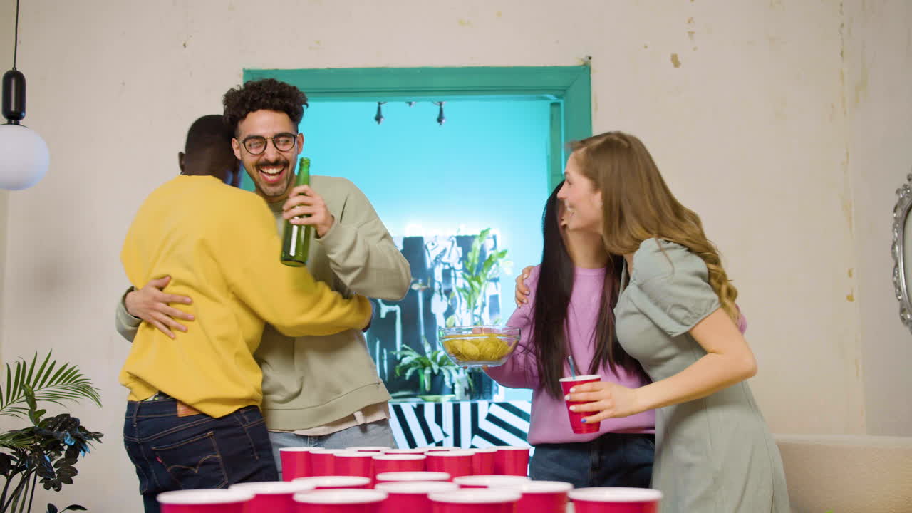 집에서 맥주 탁구를 치는 행복한 다민족 젊은 친구들