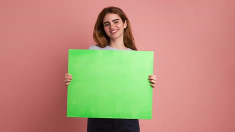 smiling young woman holding a green board