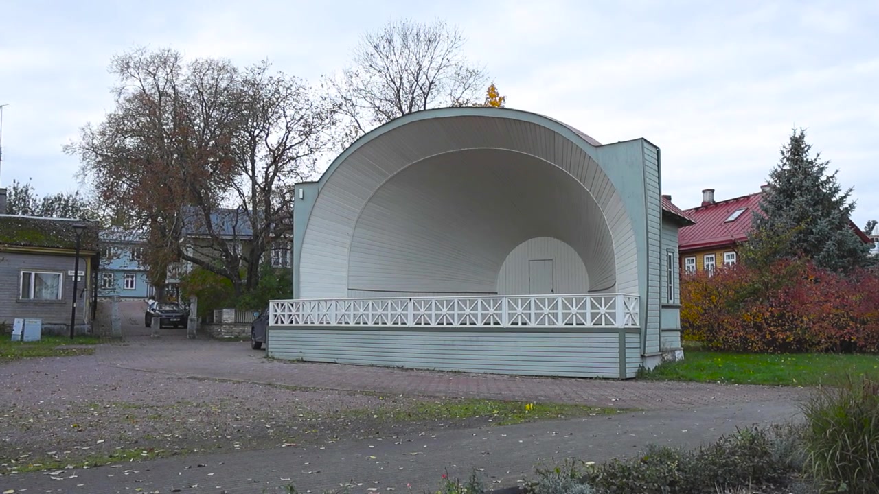 Antico palco da canto vintage e retrò o arco canoro con una splendida architettura medievale nella città di Haapsalu in Estonia durante una giornata autunnale nuvolosa. Il palco è circondato da piccoli edifici, un parco e vegetazione