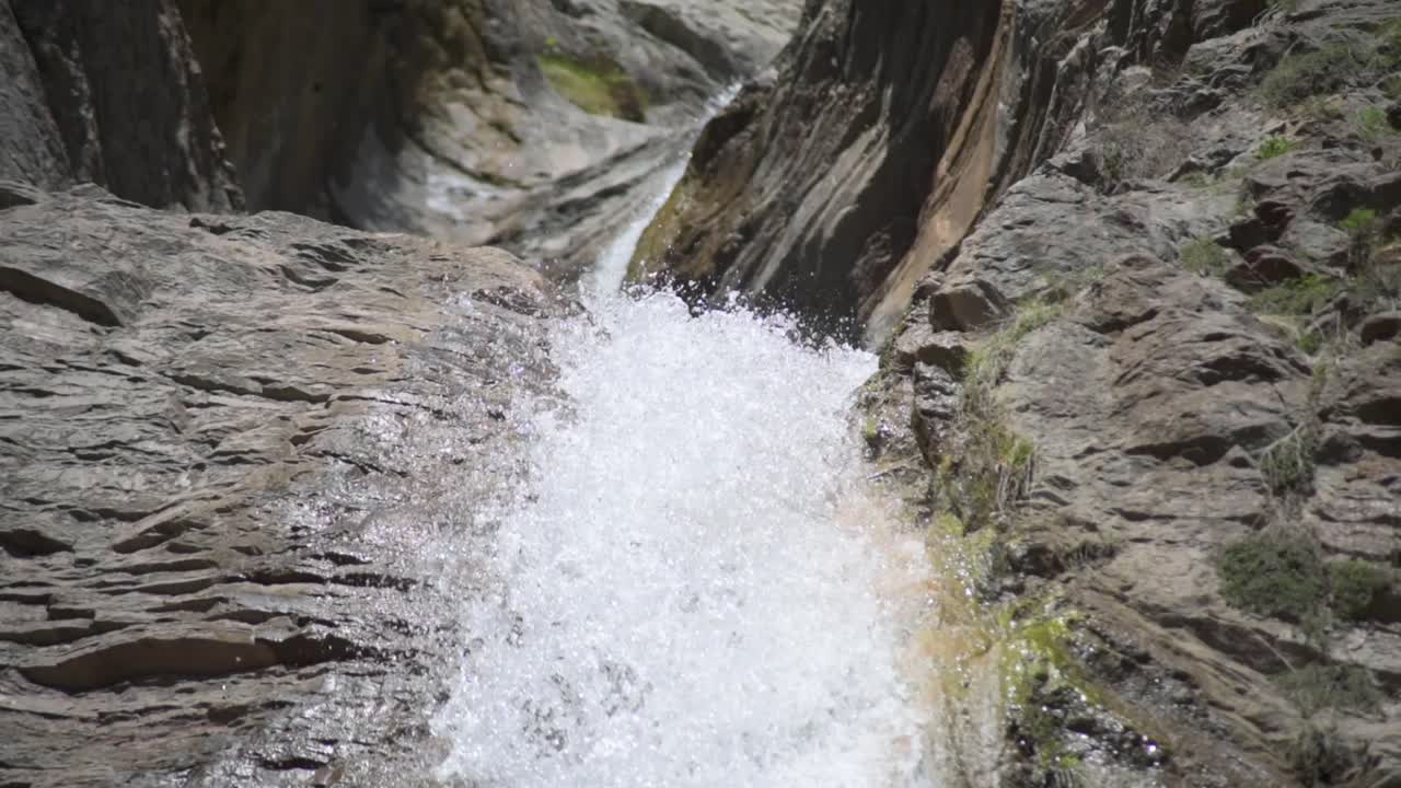 Close up a waterfall with water walling from high up through the rocks on a mountain