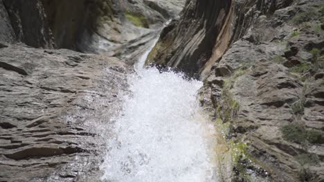 close up a waterfall with water walling from high up through the rocks on a mountain