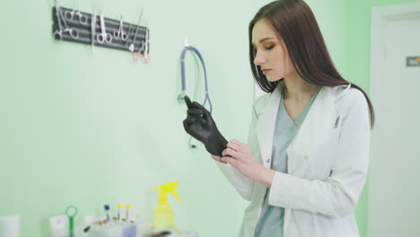 el médico se pone guantes en una clínica.