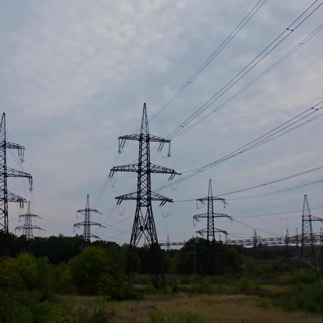 High voltage electrical substation over sunset background with transformers