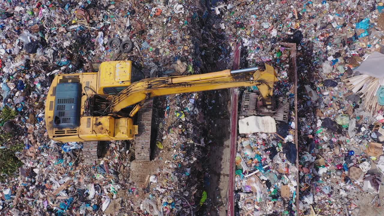 도시 쓰레기 매립장. 발굴기가 트럭에서 쓰레기를 내습니다. 고체 폐기물 매립지. 위에서 볼 수 있습니다.
